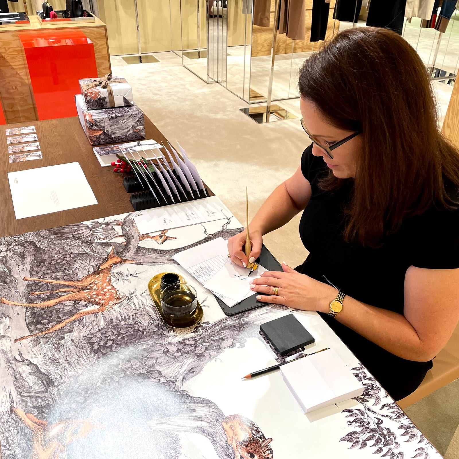 Alison writing Christmas calligraphy at an in-store table